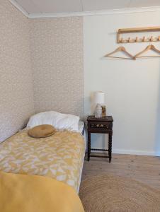 a bedroom with a bed and a side table at Sergel B&B Lindshammar in Lindshammar