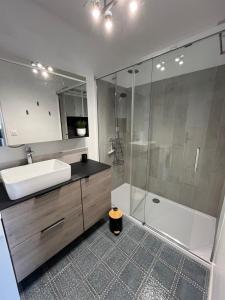 a bathroom with a sink and a shower and a tub at Mathilda front de mer 9e étage in Le Touquet-Paris-Plage