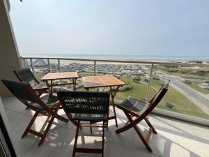 a balcony with tables and chairs and a view of the ocean at Mathilda front de mer 9e étage in Le Touquet-Paris-Plage