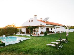 a house with a yard with a pool and chairs at Monte do Trancoso in Alvito