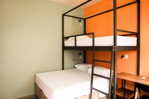 a room with two bunk beds and a desk at Local Hostel e Suites Belem in Belém +68 photos