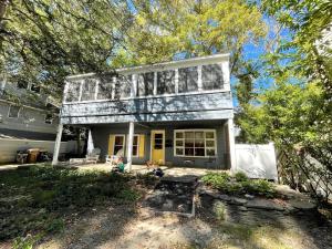 an old house with a yellow door and trees at Oak avenue 49 in Rehoboth Beach