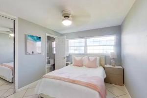 Aqua Vista Cape Coral Waterfront Haven في كيب كورال: غرفة نوم بيضاء مع سرير وحمام