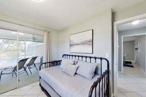 Aqua Vista Cape Coral Waterfront Haven في كيب كورال: غرفة نوم بسرير وشرفة مع كراسي +16 صورة