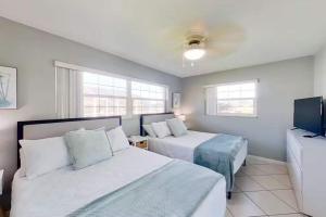 Aqua Vista Cape Coral Waterfront Haven في كيب كورال: غرفة نوم بها سريرين وتلفزيون بشاشة مسطحة
