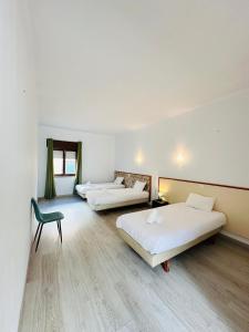 a hotel room with two beds and a chair at Residencial Pimenta ,Portimao,Algarve in Portimão