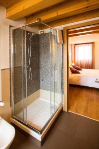 a glass shower in a room with a bedroom at Hotel All'Arco in Trieste
