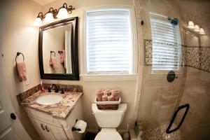 a bathroom with a toilet and a sink and a shower at Lavish 5 Bedroom, 4 Bath Pool Home 3/4 Mile To Disney in Anaheim +13 photos
