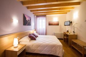 a bedroom with a bed and a desk and a window at Hotel All'Arco in Trieste