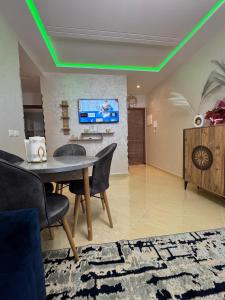 a living room with a table and a tv on the wall at Comfort Airport House 3min To Airport air-conditioned rooms in Tangier