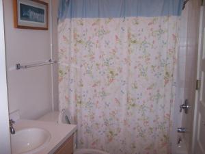 a bathroom with a shower curtain with flowers on it at Rolling road 3 in Rehoboth Beach +8 photos