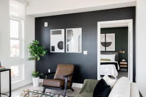 a bedroom with black walls and a bed with a mirror at Serenity in Style | Espadin LoHi in Denver