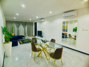 a living room with a glass table and chairs at 7th Heaven luxury Apartment in Gaborone