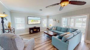 a living room with a blue couch and a table at Recently Updated Home w/ Private Pier/Boat Slip in Orange Beach
