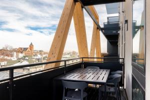 a balcony with a wooden table and chairs at Serenity in Style | Espadin LoHi in Denver