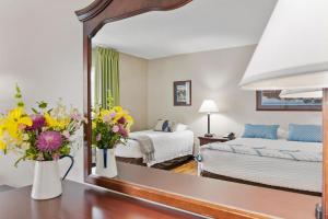 a hotel room with two beds and flowers in a mirror at Top Floor Handicap Accessible Bay View in North East
