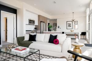 a living room with a white couch and a kitchen at Serenity in Style | Espadin LoHi in Denver