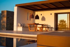 a villa with a swimming pool and a table at Ayana in Naxos Chora