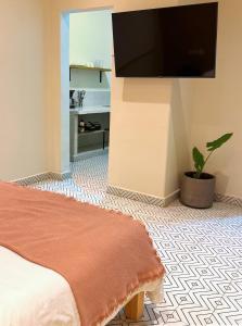 a bedroom with a bed and a flat screen tv at Loft Americana Stay Chapultepec Guadalajara in Guadalajara