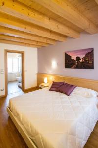 a large white bed in a room with wooden ceilings at Hotel All'Arco in Trieste