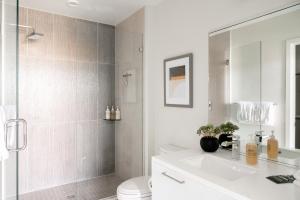 a bathroom with a shower and a sink and a toilet at Serenity in Style | Espadin LoHi in Denver +30 photos