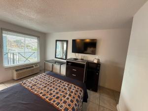una camera da letto con un letto e una TV a schermo piatto di Blue Marlin Motel a Virginia Beach