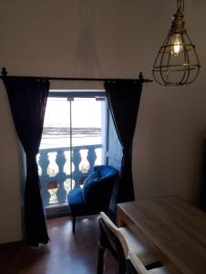 sala de estar con silla azul y ventana en k'uychi Wasi, en Cusco