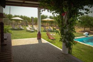 a patio with chairs and umbrellas next to a pool at Monte do Trancoso in Alvito