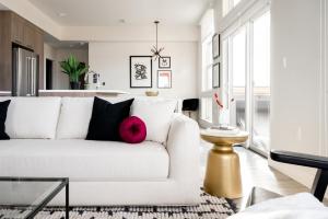 a living room with a white couch with a pink pillow at Serenity in Style | Espadin LoHi in Denver