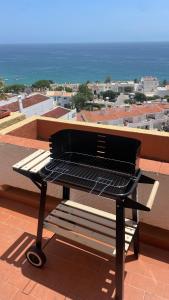 un barbecue posizionato in cima a un tetto di Luz Ocean View Apartment a Luz