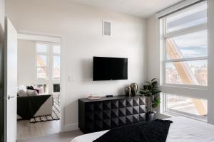 a living room with a tv on a white wall at Serenity in Style | Espadin LoHi in Denver