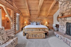een slaapkamer in een blokhut met een bed en een open haard bij Woodland log #1887 in Big Bear Lake