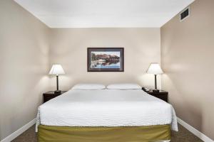 Un dormitorio con una cama blanca con dos lámparas. en Top Floor Deluxe Suite Bay View, en North East