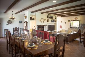 a dining room with a long table and a kitchen at Monte do Trancoso in Alvito