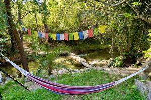a hammock in a garden with prayer flags at Cinco Lunas VEGETARIAN Guesthouse in Zahara de la Sierra +56 photos