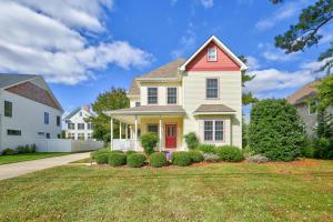 ein Haus mit einer roten Tür auf einem Rasen in der Unterkunft Robinsons drive 38223 in Rehoboth Beach