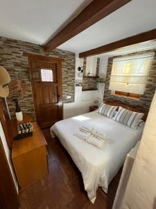 a bedroom with a large white bed and a window at Casa terrera "El Granero" in Tanque +31 photos