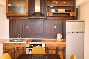 a small kitchen with wooden cabinets and a refrigerator at GV - Holiday home with MagnaPool in Makarska