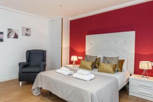 a bedroom with two beds and a chair at Waou Apartamentos en Sol Confort 6 in Madrid