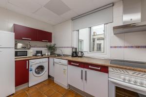 a kitchen with white cabinets and a washer and dryer at Waou Apartamentos en Sol Confort 6 in Madrid +6 photos