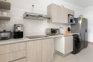 Una cocina con gabinetes de madera y refrigerador. en Viva Jaco, en Jacó 39 fotos más