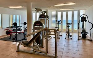 a gym with several treadmills and exercise bikes at Oceanview Costa del Mar Condo with Pool and Smart TV in Pole Ojea