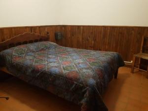 a bedroom with a bed and a wooden wall at SumayWasi in Tilcara