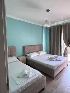 deux lits dans une chambre aux murs bleus dans l'établissement VILLA MYRTAJ, à Saranda 21 autres photos