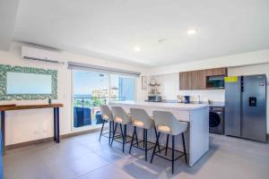 a kitchen with a counter and a bar with stools at Viva Jaco in Jacó