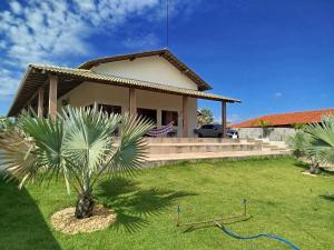 a house with a palm tree in the yard at Casa obster barrinha in Barra Grande