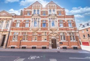 a large brick building on the corner of a street at Luxe City Stay With Free Gym & Pet Friendly Perfect For Business & Families By The Pocklington - The Graduate Suite in Leicester