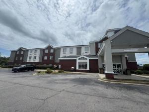 Un edificio con un coche aparcado en un estacionamiento. en Broad St Inn, en Sumter