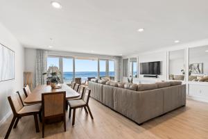 a living room with a large couch and a table and chairs at Oceanfront Penthouse Amazing Views in Oceanside