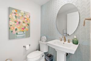 a bathroom with a sink and a mirror and a toilet at Oceanfront Penthouse Amazing Views in Oceanside +30 photos